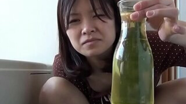 An Asian woman fills a vase with urine